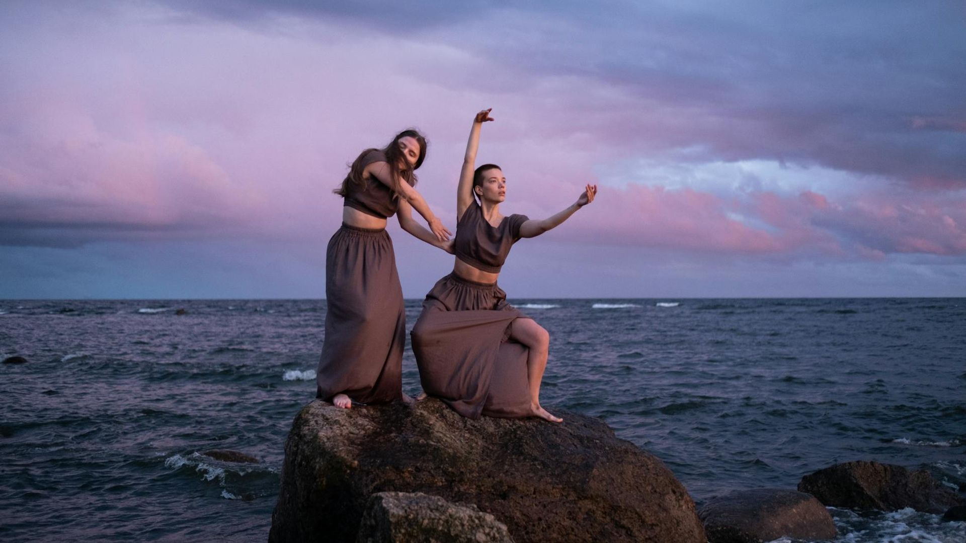 Silhouette of a woman in a dynamic, flowing cardio pose at sunrise.